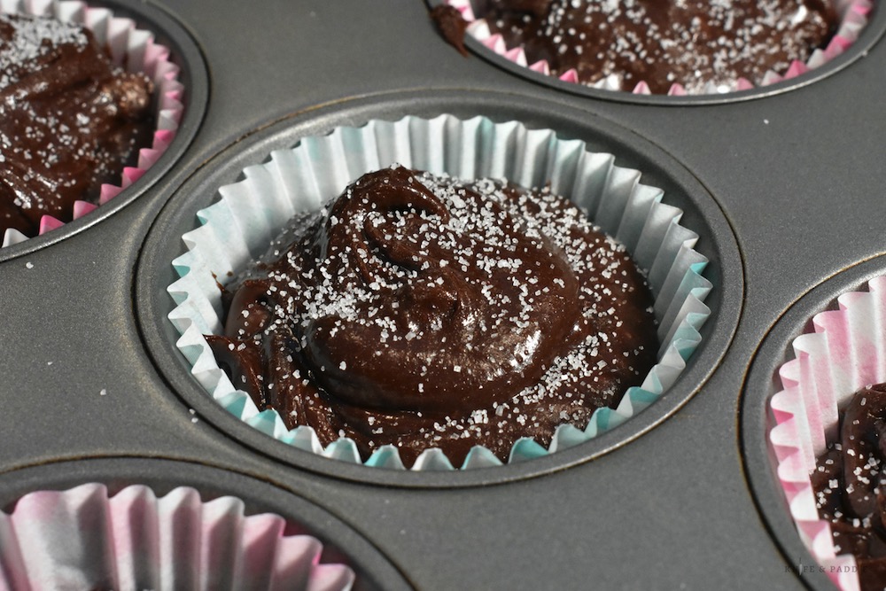Chocolate muffins batter in pan with sprinkled sugar on top