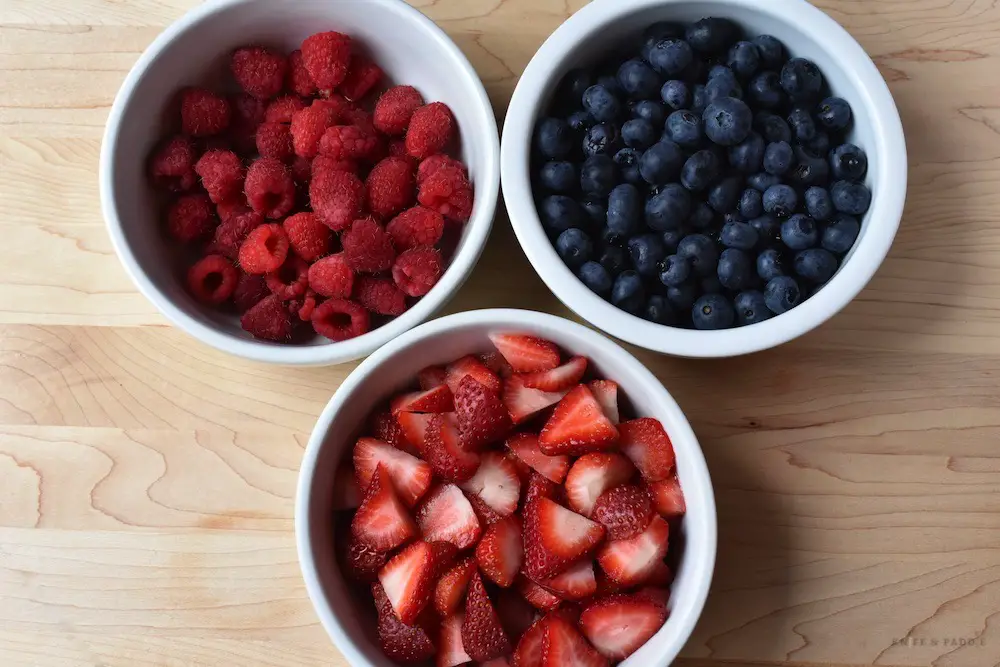 Raspberries, blueberries and strawberries in bowls