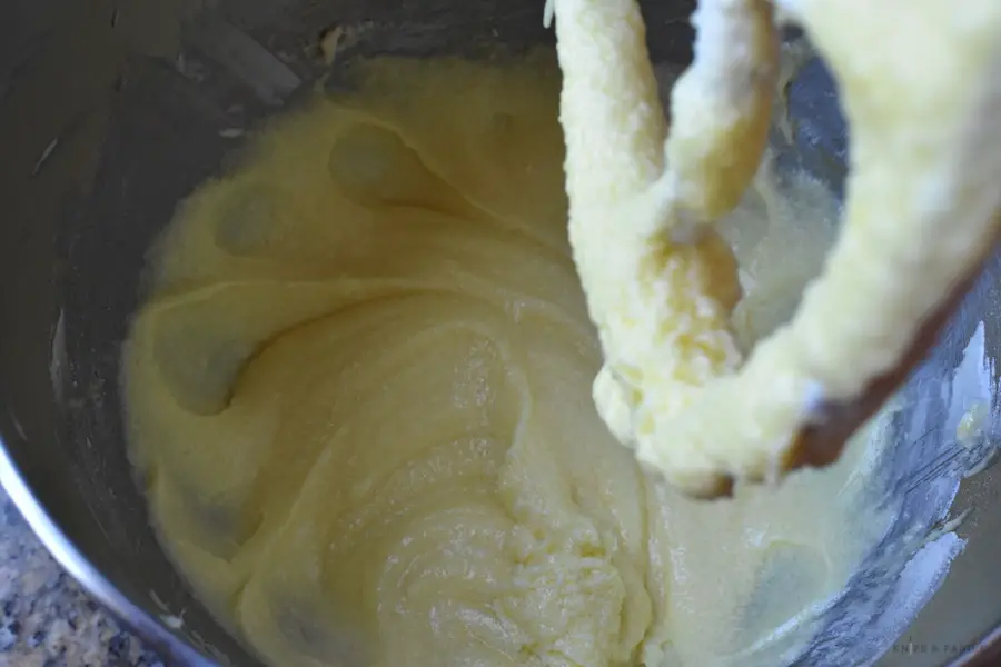 Stand mixer paddle with beaten butter, sugar, eggs and vanilla