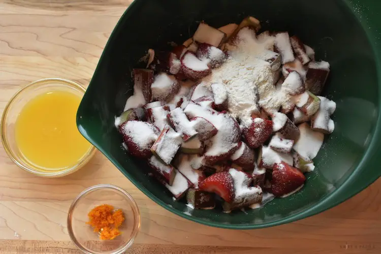 Strawberries, rhubarb, orange juice and flour in mixing bowl