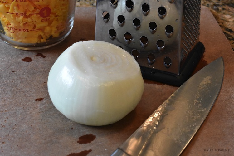 Onion, cheese, grater and knife