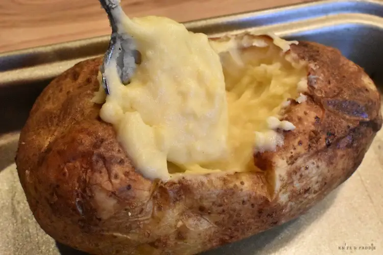 Ultimate Twice Baked Potato being stuffed