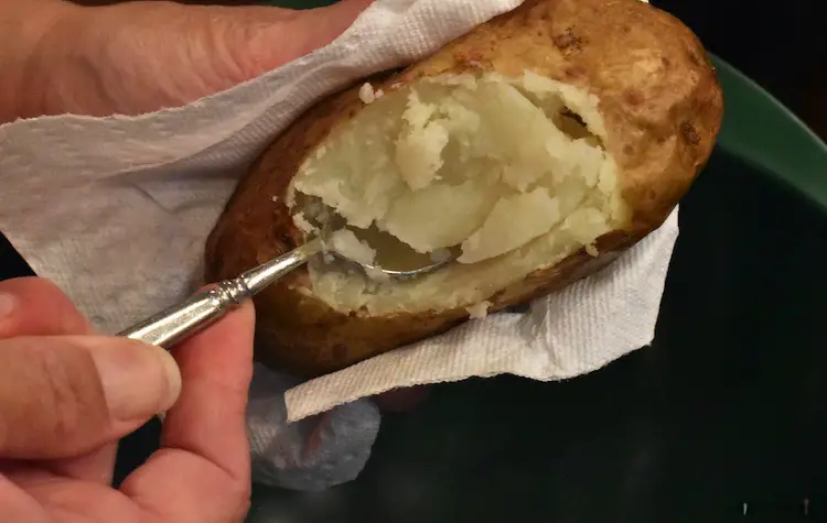 Scooping out the inside of the baked potato