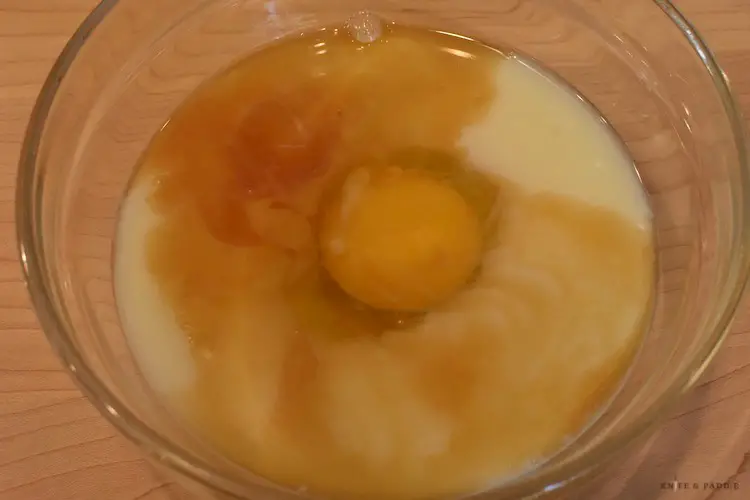 Egg, milk and vanilla in a mixing bowl
