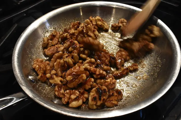 Adding sugar mixture to the toasted walnuts