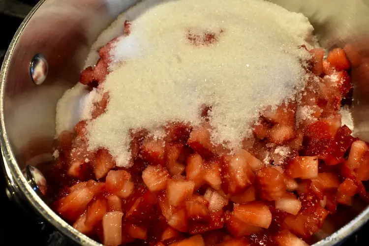 Strawberries and sugar in a saucepan