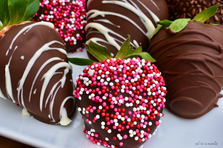 A variety of chocolate covered strawberries on a plate
