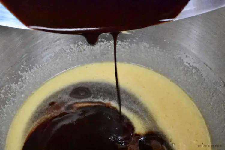 Pouring in chocolate mixture into the beaten eggs, sugar and vanilla