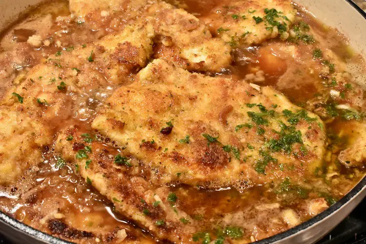 Chicken in the sauce in the skillet with parsley