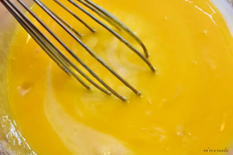 Adding the beaten egg yolks to the corn starch mixture whisk together