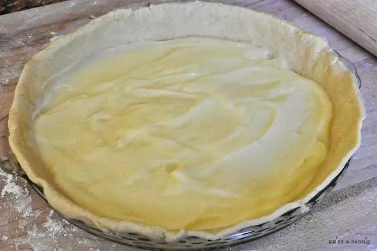 Pie plate with bottom crust and a layer of vanilla pudding