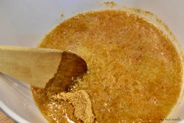 Butter and graham cracker crumbs mixed in a small mixing bowl
