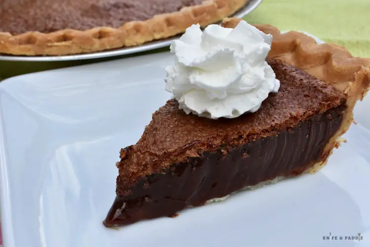 Slice of chocolate chess pie with whipped cream on top