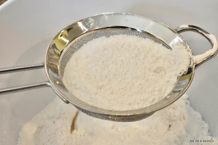 Cake flour, confectioners sugar and salt being sifted  