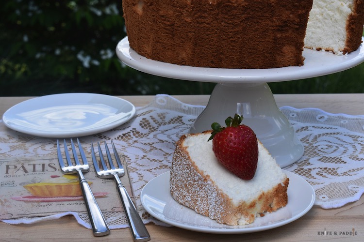 Angel Food Cake on a cake stand with a piece plated 