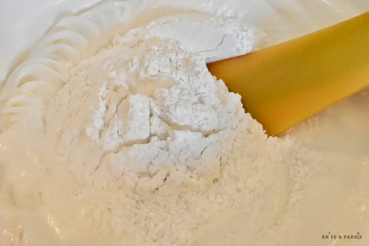 Folding the flour mixture into the beaten egg whites using a rubber spatula