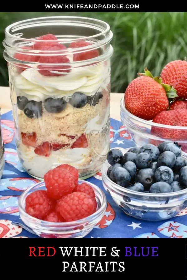 Blueberries, raspberries and strawberries in bowls with a mason jar parfait