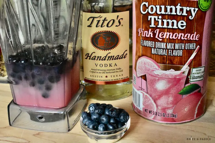 Blueberries, vodka, lemonade mix ice and water in a blender