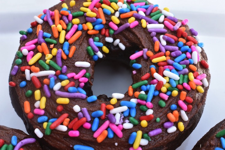 Delicious Double Chocolate Donuts with rainbow sprinkles on a white plate