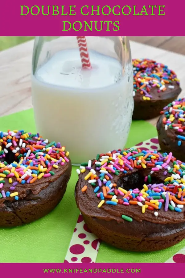 Double chocolate donuts on a napkin with a jar of milk