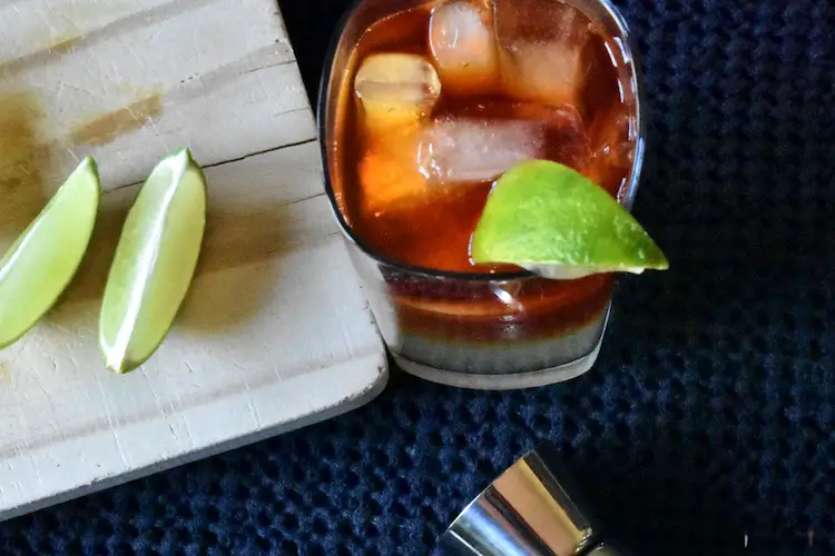 Dark 'N' Stormy Cocktail in a highball glass with a lime wedge