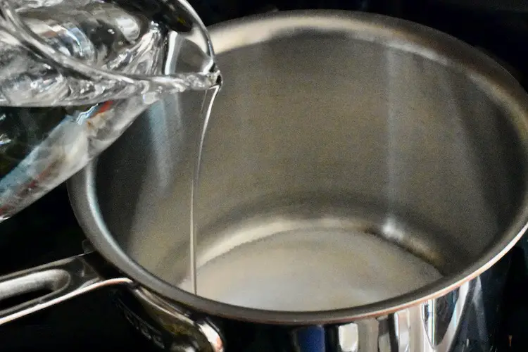 Combining sugar and water in a stove top pan