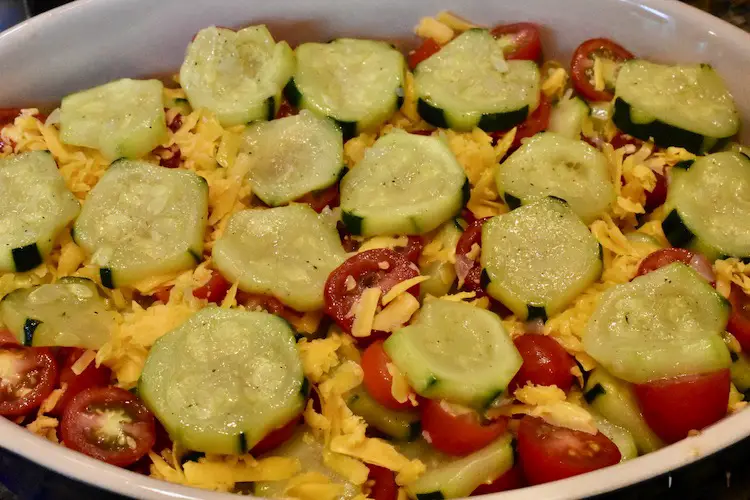 Cooked zucchini, tomatoes, cheese layered in a casserole dish