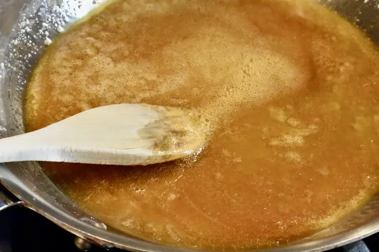Caramelized sugar and heavy whipping cream in a fry pan