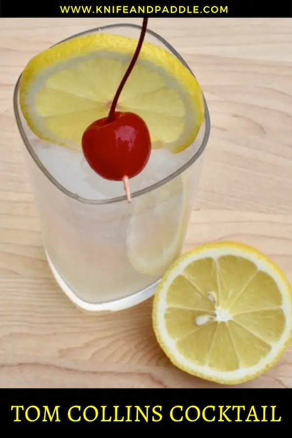 Tom Collins Cocktail in a highball glass garnished with a lemon wheel and a maraschino cherry