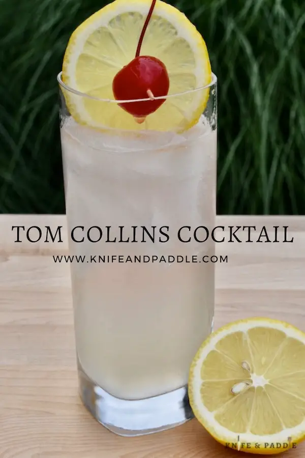 Tom Collins Cocktail in a highball glass garnished with a lemon wheel and a maraschino cherry