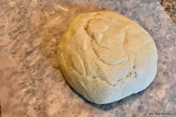 Dough gathered into a disk on wax paper
