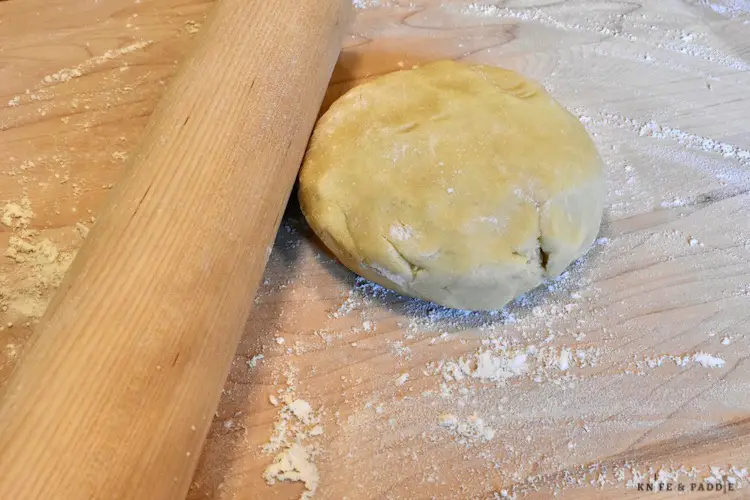 Rolling pin, floured board and dough disk