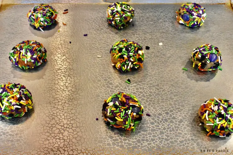 Halloween sprinkled dough balls on a baking sheet