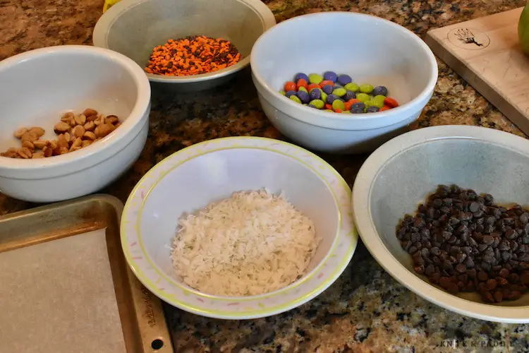 Peanuts, sprinkles, M&Ms, chocolate chips and coconut in bowls