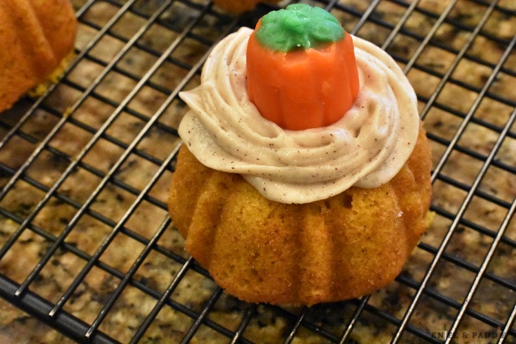 Mini pumpkin cake with cinnamon butter cream cheese frosting on a wire rack