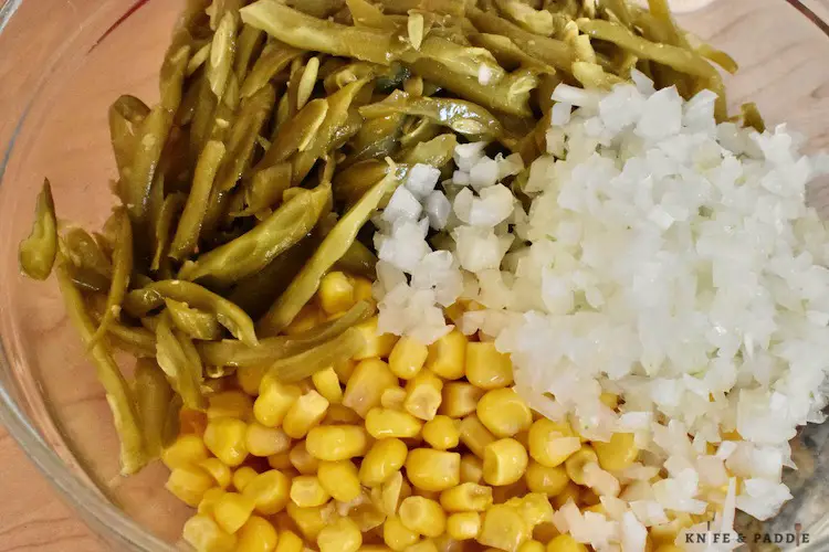Green beans, diced onion and corn in a mixing bowl