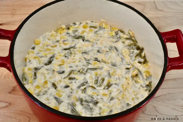 Sharp shredded cheddar cheese, sour cream, corn, Ritz crackers, garlic powder, onion, green beans, pepper, cream of celery soup and butter mixed together in a 8-inch casserole dish.