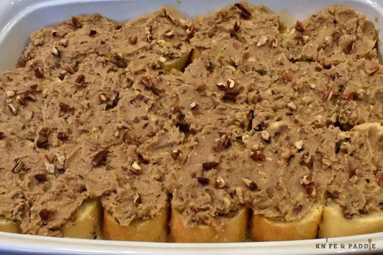 Egg, cinnamon and milk dipped bread slices in a baking dish with praline topping