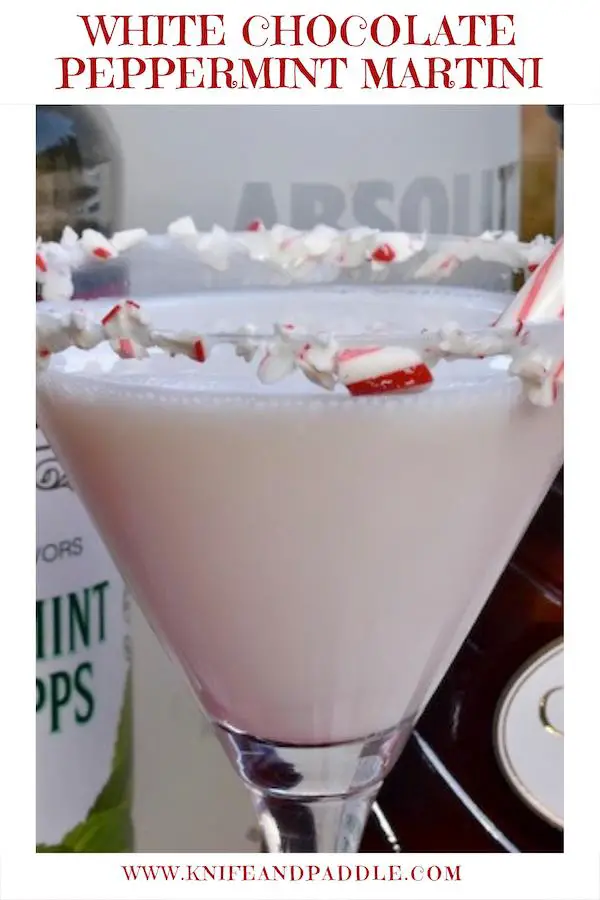 White Chocolate Peppermint Martini in a martini glass coated with marshmallow topping and crushed candy canes