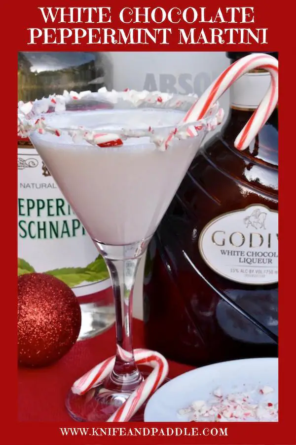 White Chocolate Peppermint Martini in a martini glass coated with marshmallow topping and crushed candy canes
