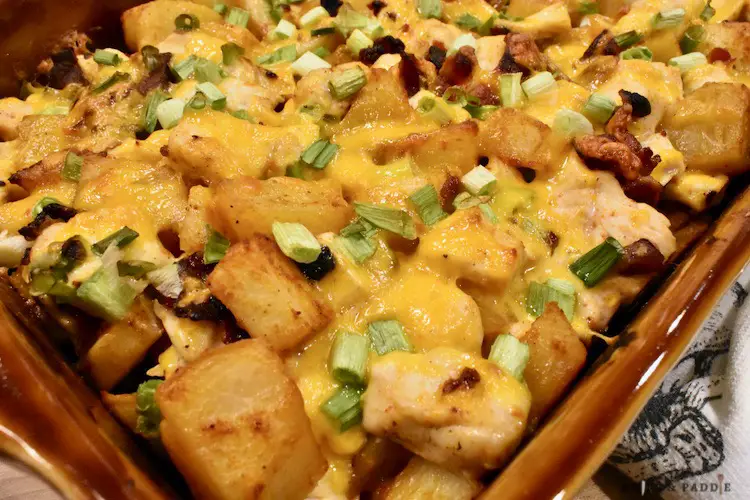Salt, hot sauce, olive oil, chili powder, paprika, ground pepper, garlic powder, extra sharp cheddar cheese. green onions, potatoes, chicken and bacon in a baking dish right out of the oven.