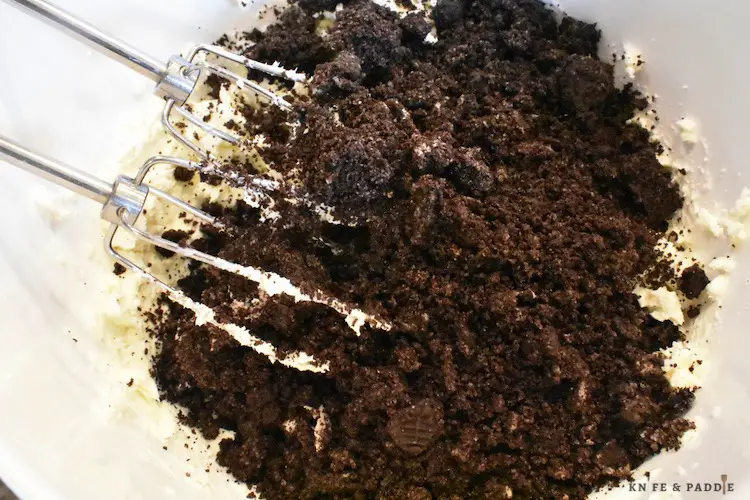 Crushed Oreos, pure vanilla extract, cream cheese in a mixing bowl.