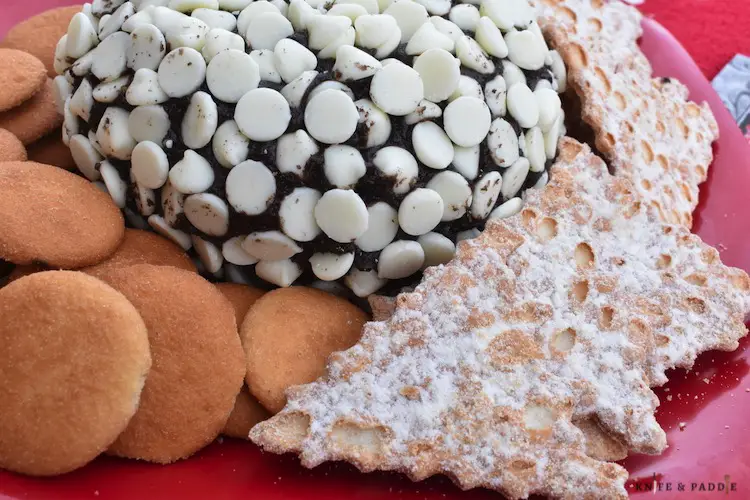 Oreo Crean Cheese Ball on a plate with vanilla wafers and cannoli chips