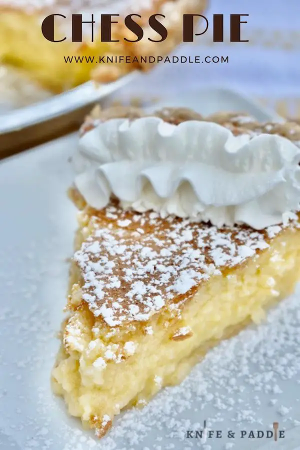 Slice of chess pie with powdered sugar and whipped cream on a plate