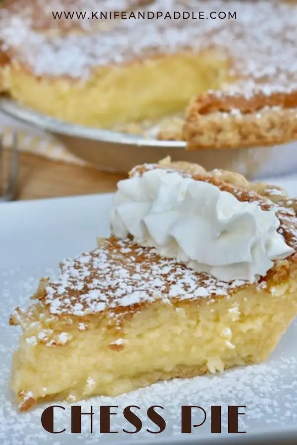 Slice of chess pie with powdered sugar and whipped cream on a plate