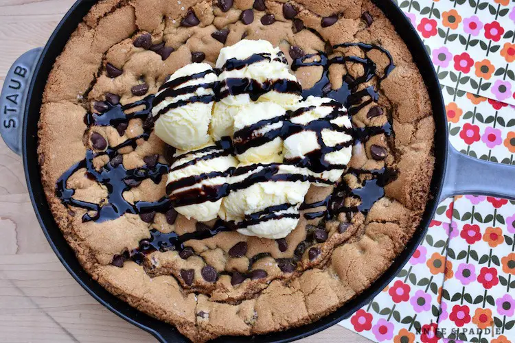 Cast iron pan with warm cookie smothered with vanilla ice cream and chocolate sauce