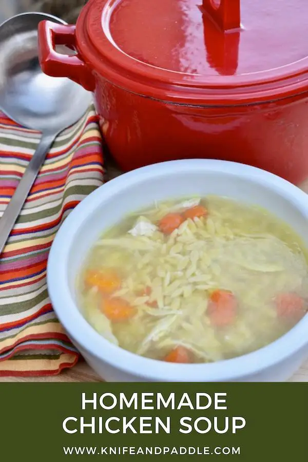 Broth, carrots, chicken, and orzo in a bowl