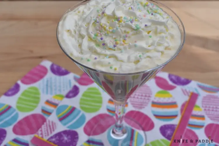 Cocktail topped with whipped cream and pastel nonpareils