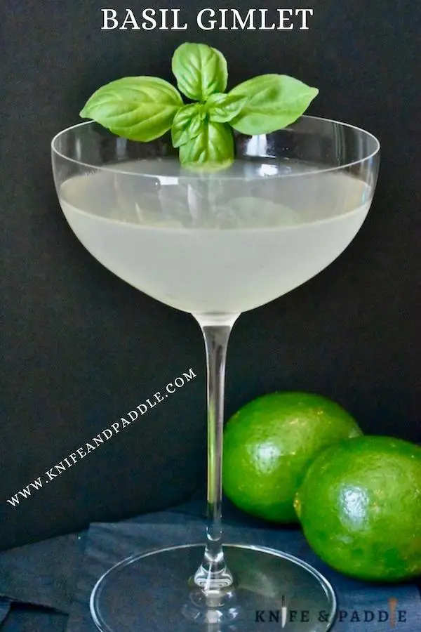 Cocktail in a coup glass with fresh limes