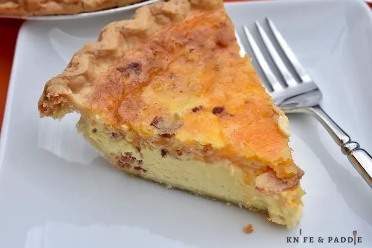 Slice of eggs, bacon and cheddar cheese in a flaky pie crust